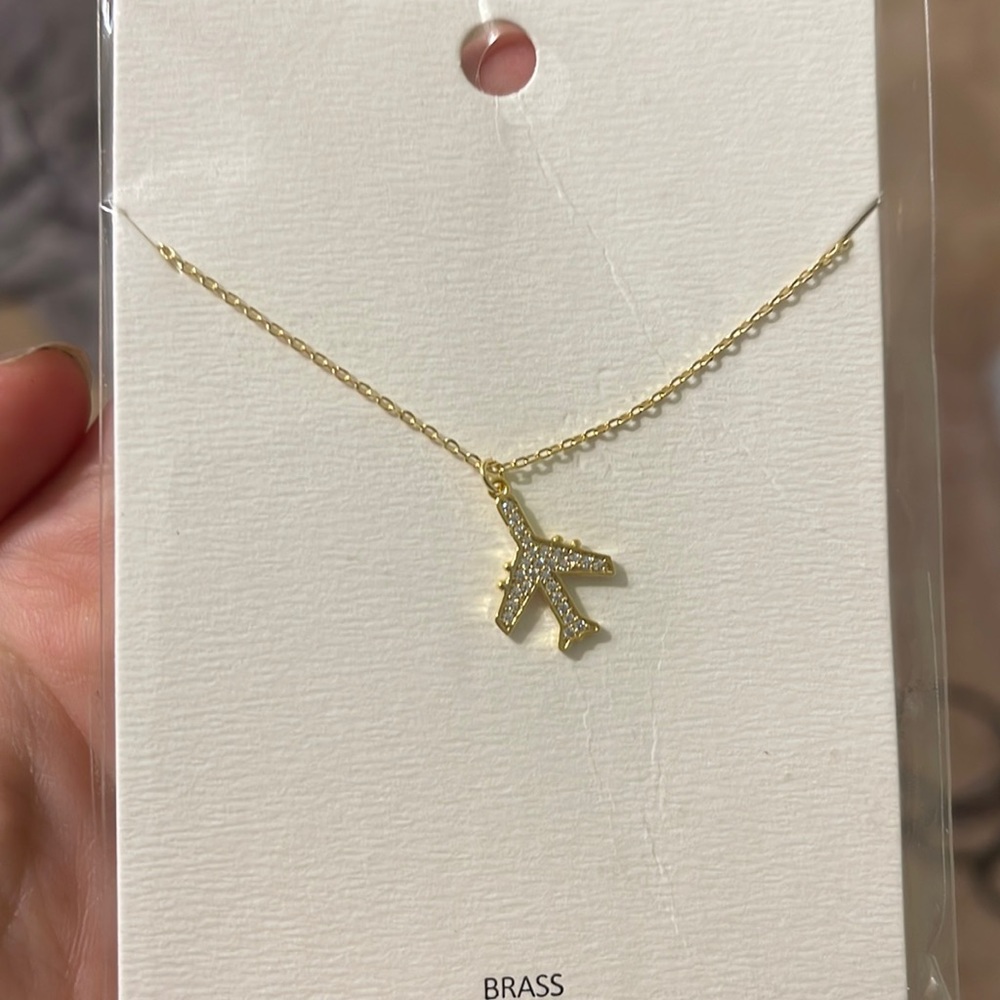 Brass/gold tone necklace with a sparkly airplane
